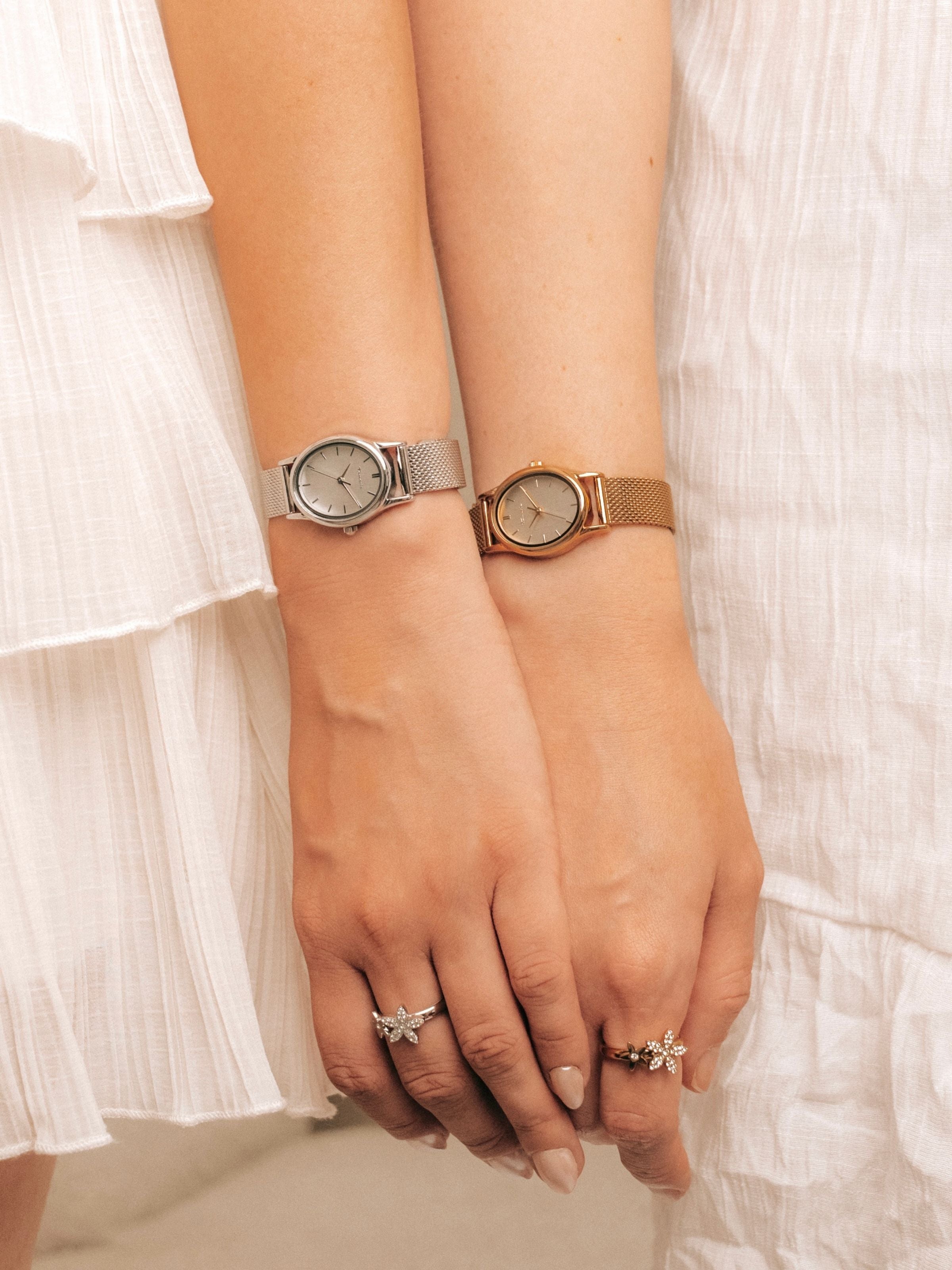 Tamaris Neuheiten – zwei Damen mit silberner und goldfarbener Armbanduhr sowie floralen Ringen