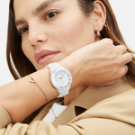 Model trägt das Tamaris Herz-Armband „The Love Heart“ aus roségoldfarbenem Edelstahl kombiniert mit einer weißen Tamaris Armbanduhr.