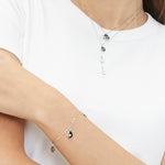 Tamaris Armband bestehend aus einer filigranen, silbernen Kette und drei kleinen Charms mit verschiedenen Sternmotiven und Glitzersteinverzierungen; Tragebild