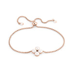 Das Tamaris Armband - The Flower Pearl von Tamaris hat ein roségoldenes Design mit vier weißen Perlen, die in einem floralen Mittelstück angeordnet sind und für einen eleganten, zarten Look sorgen.