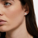Nahaufnahme einer Frau, die den kleinen, silbernen Tamaris Ohrstecker - The T-Pattern Heart in ihrem linken Ohr trägt - ein elegantes Accessoire von Tamaris und ein perfektes Geschenk für einen besonderen Menschen.
