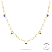 Tamaris Halskette - Die Silber Kollektion von Tamaris: Gold Gliederkette aus 925er Sterling Silber mit fünf gleichmäßig angeordneten blauen Edelsteinanhängern, auf weißem Hintergrund präsentiert.