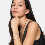 Frau in einem schwarzen ärmellosen Top trägt Silberschmuck und das Tamaris Armband - The Edge und posiert schick mit der Hand unter dem Kinn - ein stilvolles Tamaris-Accessoire für Frauen.