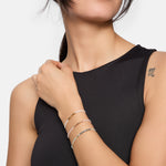 Model trägt Tamaris Armband mit weißen Perlen, goldfarbenen Akzenten und verstellbarem Zugverschluss am Handgelenk.