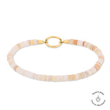 Das Tamaris Armband - All About Beads besteht aus hellpfirsich- und cremefarbenen Scheibenperlen, beigen Steinen, einem goldenen Verschluss und dem kultigen Tamaris Jewel Charms Logo.