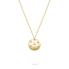 Die Tamaris Halskette - Little Twinkle von Tamaris besteht aus einer goldenen Halskette mit einem runden Anhänger, der mit kleinen Sternen und funkelnden Zirkoniasteinen verziert ist.