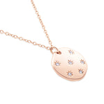 Die Tamaris Halskette - Little Twinkle ist eine roségoldene Damenkette mit rundem Anhänger, verziert mit sechs wie Sterne angeordneten Zirkonia-Schmucksteinen.