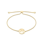 Das Tamaris Armband - Little Twinkle ist ein goldenes Kettenarmband mit einem runden, polierten Scheibenanhänger mit eingravierten Sternmotiven und funkelnden Zirkoniasteinen. Sein verstellbarer Schiebeverschluss macht es zu einem zarten, stilvollen Stück von Tamaris.
