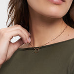 Frau trägt ein olivgrünes Oberteil und die Tamaris Halskette - Charm Series, eine zarte Goldkette mit rundem Anhänger von Tamaris - perfekter eleganter Schmuck für jeden Anlass.