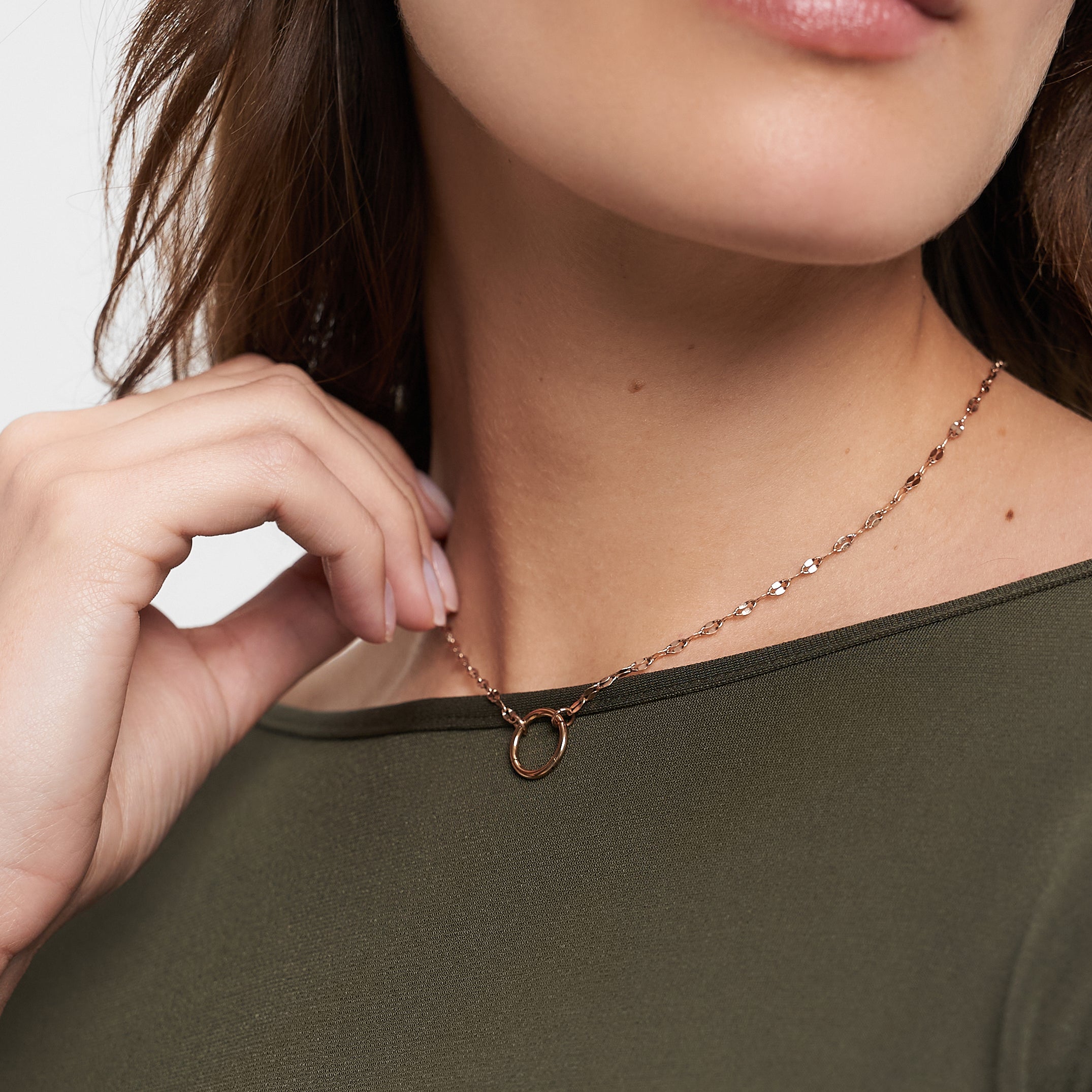 Frau trägt ein olivgrünes Oberteil und die Tamaris Halskette - Charm Series, eine zarte Goldkette mit rundem Anhänger von Tamaris - perfekter eleganter Schmuck für jeden Anlass.