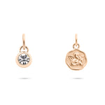 Das Tamaris Charms Bundle - Charm Series von Tamaris enthält zwei goldene Charms: einen mit einem funkelnden Zirkonia-Stein und einen gravierten Engelcharm mit Engelsmotiv, beide an kleinen Schlaufen.