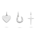 Das Tamaris Charms Bundle - Charm Series bietet drei silberne Anhänger - ein Herz, ein Hufeisen mit Strass und ein Kreuz - perfekter Schmuck für Frauen, elegant präsentiert auf weißem Hintergrund.