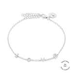 Das Tamaris-Armband aus der Silver Love Collection ist mit kleinen geometrischen Anhängern, funkelnden Zirkonia-Akzenten und einem runden LOVE-Anhänger auf weißem Hintergrund versehen.