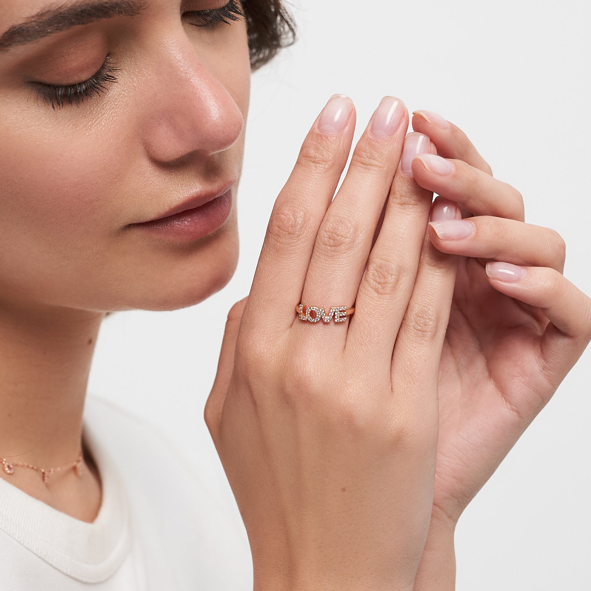 Eine Frau mit geschlossenen Augen berührt sanft ihr Gesicht und präsentiert einen Tamaris Ring aus der Silver Love Collection an ihrem Finger.