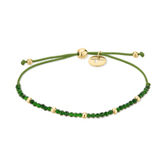 Das Tamaris Damen Armband - Beads besticht durch grüne Kordel, kleine Natursteinperlen, goldene Akzente und einen verstellbaren Zugbandverschluss mit einem stilvollen goldenen Schieber. Ideal, um jedem Look Charme zu verleihen. Marke: Tamaris.
