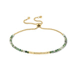 Tamaris Damenarmband aus Edelstahl mit grüner Natursteinperlen-Reihe, goldfarbenen Akzenten und verstellbarem Zugverschluss.