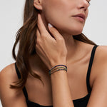 Tamaris Damenarmband mit grünem Naturstein, goldfarbenen Edelstahlelementen und praktischem Zugverschluss am Handgelenk getragen.