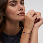 Model trägt Tamaris Armband mit blauen Natursteinperlen, goldfarbenen Details und verstellbarem Textilband.