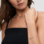 Model trägt Tamaris Armband „Pearl Flower“ mit Süßwasserzuchtperlen und filigranen Blumenanhängern aus silberfarbenem Edelstahl.