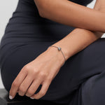 Silberfarbenes Tamaris Armband mit Herzdetail am Handgelenk eines Models