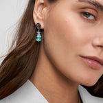 Model trägt die silbernen Tamaris Hängeohrringe mit blauem und türkisem Perlen-Anhänger am Ohr.