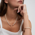 Tamaris Pearl Charms Armband mit weißen Perlen und roségoldfarbenem Charm-Verschluss am Handgelenk