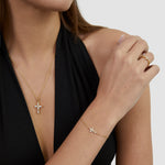 Tamaris Cross Armband in Gold mit funkelndem Zirkonia-Kreuz am Handgelenk getragen