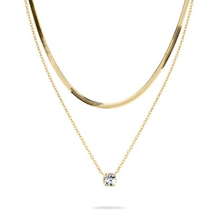 Peppen Sie Ihren Look mit dem Tamaris Set - The Layer auf. Es besteht aus zwei goldenen Halsketten: einer eleganten Schlangenkette und einer zarten Layer mit einem kleinen quadratischen Anhänger.