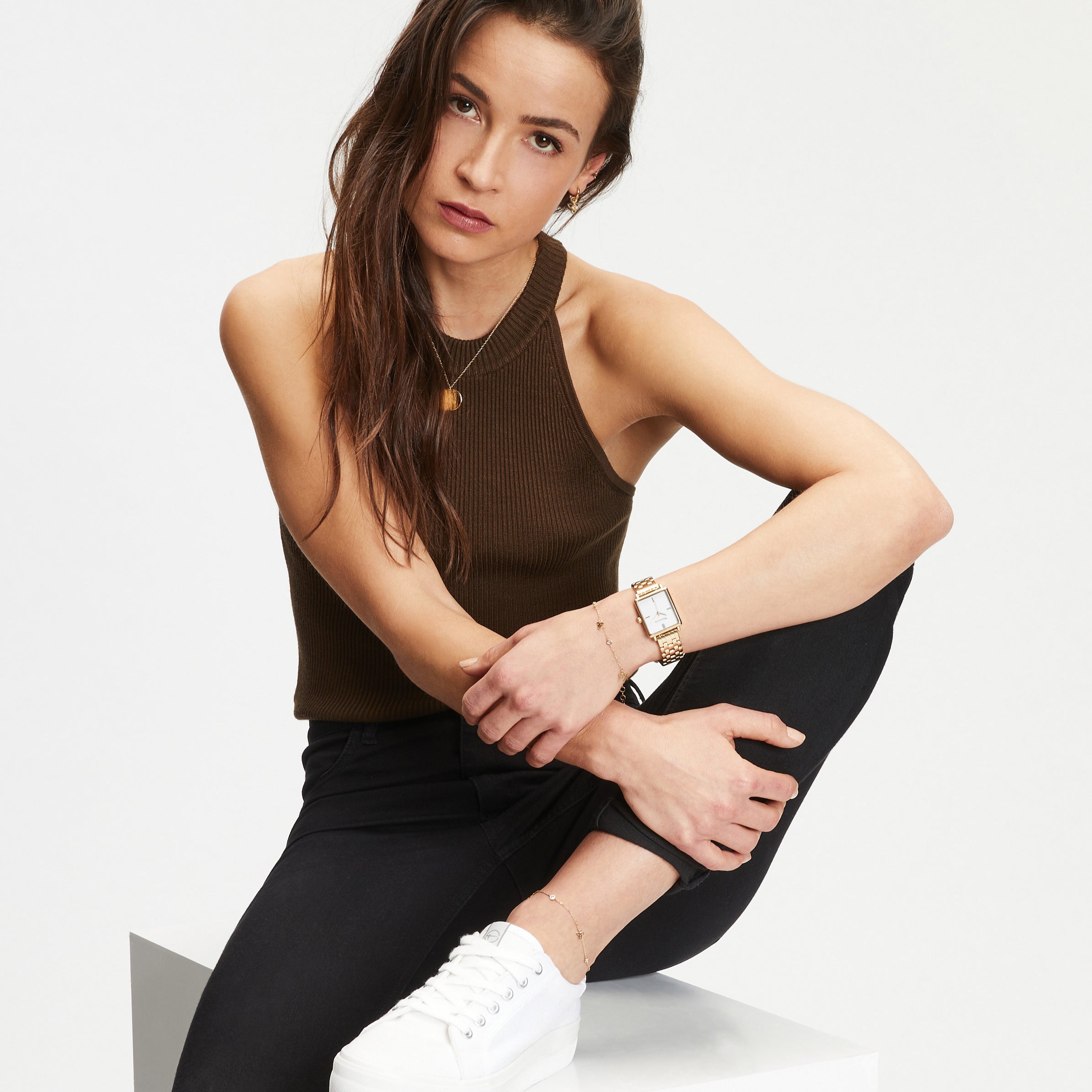 Model trägt Tamaris Damenuhr mit rechteckigem Gehäuse und goldfarbenem Edelstahlarmband kombiniert mit passendem Kugelarmband.