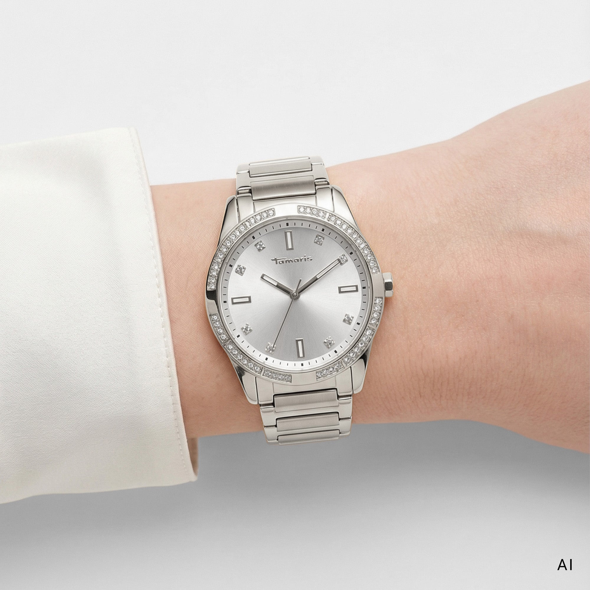 KI-generiertes Tragebild einer silberfarbenen Tamaris Damen Armbanduhr mit Edelstahlarmband, hellem Zifferblatt und funkelndem Steinbesatz an der Lünette.