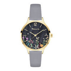 Die Tamaris Armbanduhr - Romantic Flowers von Tamaris hat ein goldenes Gehäuse, ein graues Armband und ein florales Design auf dem dunklen Zifferblatt mit goldenen Stundenmarkierungen - eine elegante Lederuhr, die zu jedem Anlass passt.