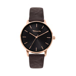 Die Tamaris Armbanduhr Stamped Flowers hat einen goldenen Rand, ein schwarzes Zifferblatt und ein braunes Lederarmband mit minimalen goldenen Stundenmarkierungen - eine elegante Tamaris-Uhr für jeden Anlass.