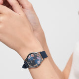 Eine Person, die eine Tamaris Armbanduhr - Sporty Flowers von Tamaris trägt, stellt die blaue Blumenuhr mit sportlichem Silikonband an ihrem linken Handgelenk ein.