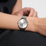 Die Tamaris Armbanduhr - Shiny Stars von Tamaris verleiht mit ihrem silbernen Netzband einem schwarzen Outfit einen Hauch von Eleganz und modernem Stil.