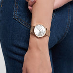 Eine Person, die Blue Jeans und eine Tamaris Armbanduhr - Shiny Stars von Tamaris trägt und ihre Hand in die Nähe ihrer Hüfte legt.