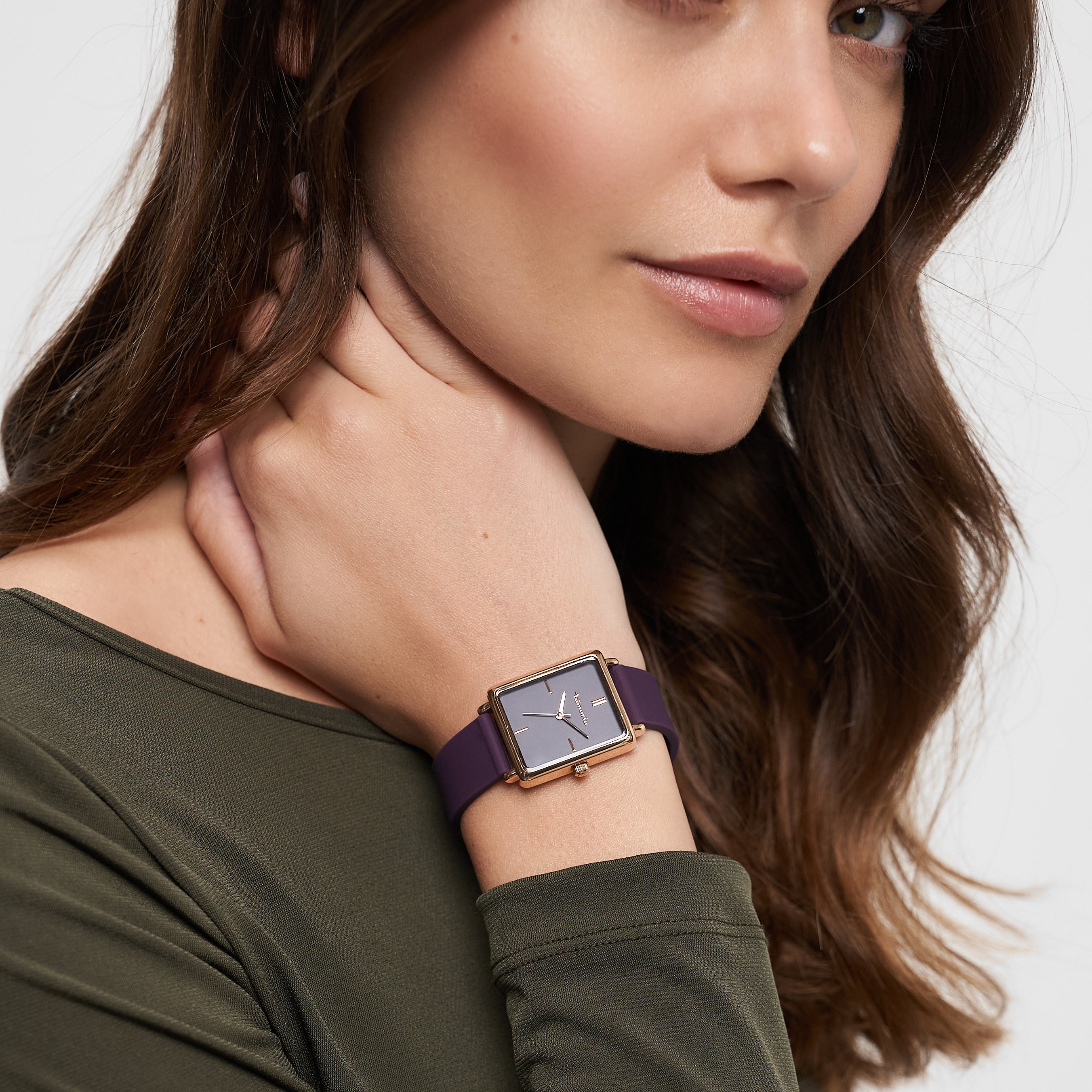 Frau mit langen braunen Haaren trägt ein olivgrünes Oberteil und eine Tamaris Armbanduhr - The Silicon Square von Tamaris und schaut in die Kamera.