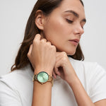 Tamaris Everyday Hero Damenuhr in Gold mit grünem Zifferblatt und goldenem Gliederarmband am Handgelenk getragen