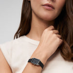Tamaris Tiny Watch am Handgelenk getragen mit schwarzem Zifferblatt, silberfarbenem rechteckigem Gehäuse und schwarzem Lederarmband